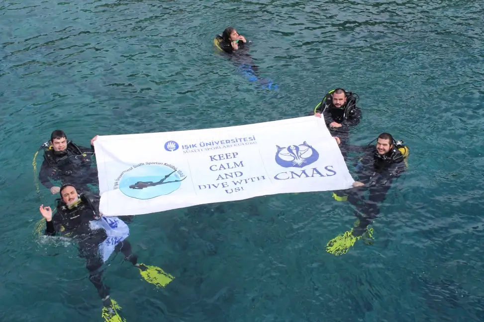 Işık University diving club students in diving gear in water