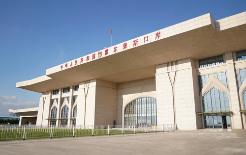 Pale border-crossing building with red Chinese lettering and arched windows