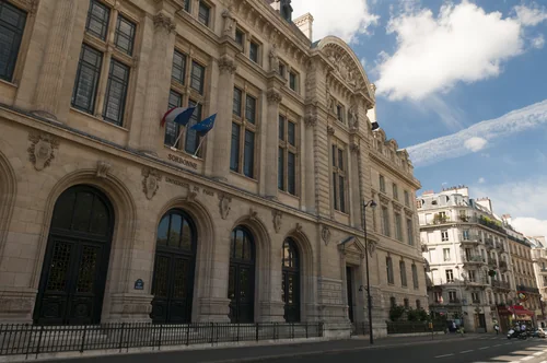 Pale stone façade inscribed Sorbonne and Université de Paris, with French and EU flags