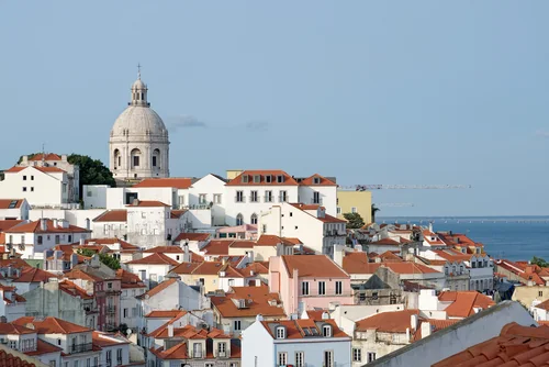 White houses with tiled roofs, a church dome and the Tagus river