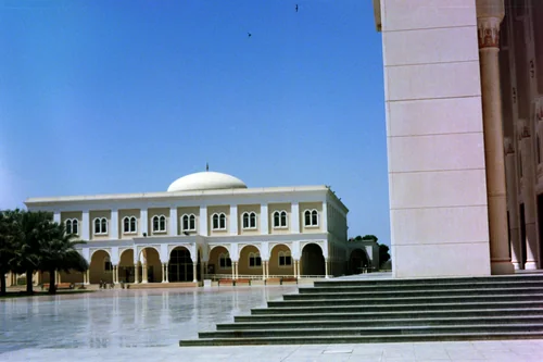White domed building with an arched gallery, marble steps and a column on the right
