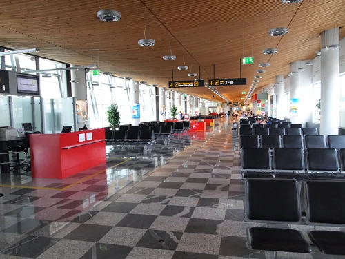 Waiting area with rows of seats, a wooden ceiling and a chequered floor