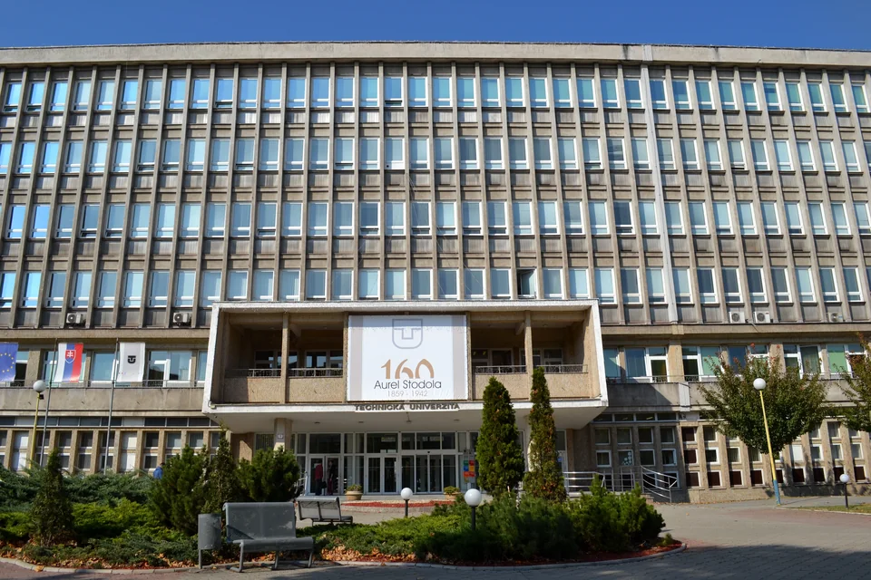 Многоэтажный корпус с ленточными окнами и вывеской над входом